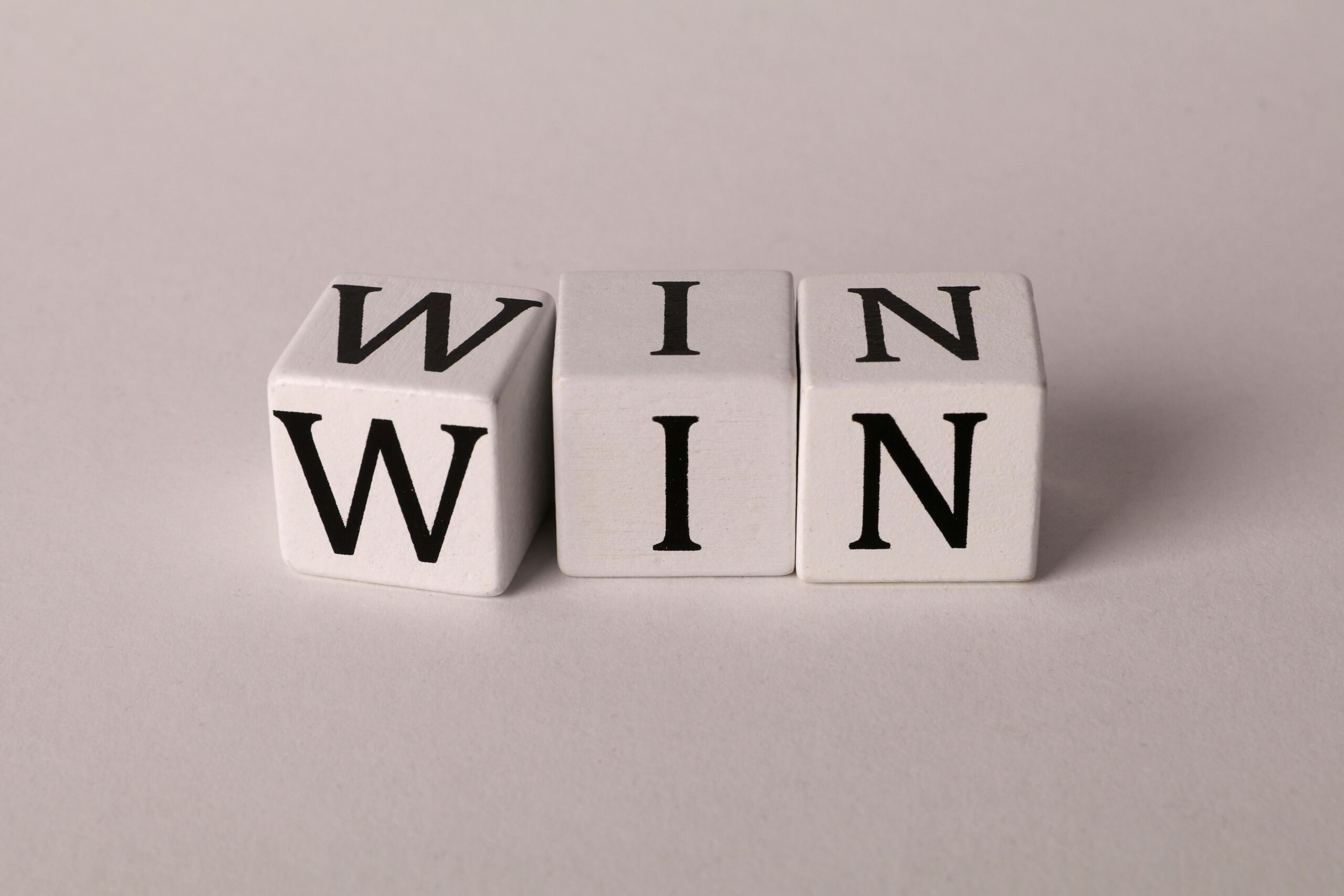 White cubes with the word 'WIN' against a light background symbolizing success and achievement.